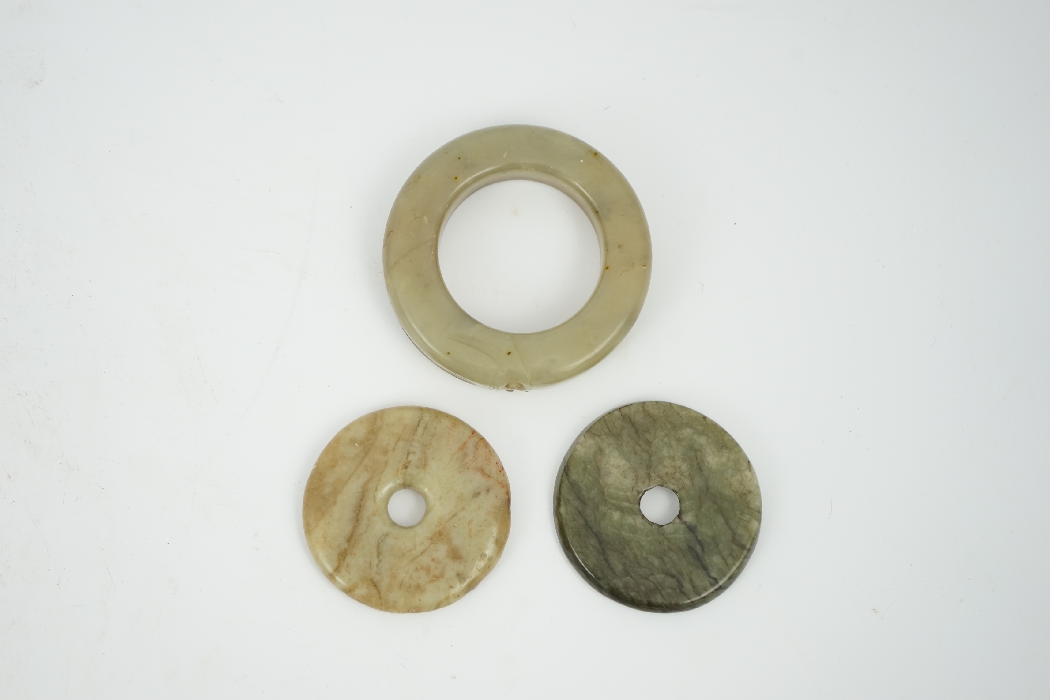 Two Chinese soapstone bi discs, and a jade ring, 18th century or earlier, largest 6.5cm in diameter. Condition - good